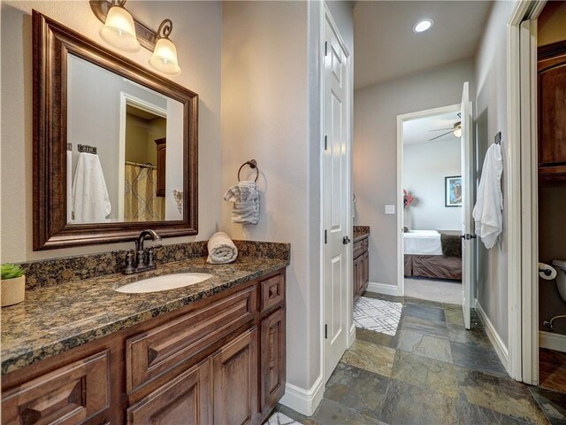 8409 Lago Vista Dr, Corpus Christi, TX 78414 - bathroom featuring stone tile flooring, baseboards, ceiling fan, vanity, and connected bathroom