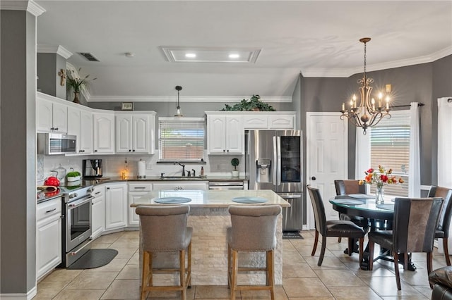 7425 Bourget Dr, Corpus Christi, TX 78413 - kitchen with stainless steel appliances, a sink, light tile patterned floors, white cabinetry, and a kitchen island