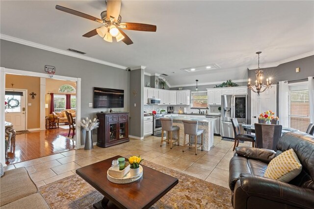 7425 Bourget Dr, Corpus Christi, TX 78413 - living area featuring ornamental molding, light tile patterned flooring, a chandelier, ceiling fan, and healthy amount of natural light
