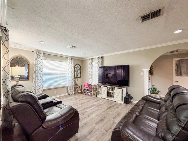 living room featuring ornate columns, a textured ceiling, crown molding, and light hardwood / wood-style flooring