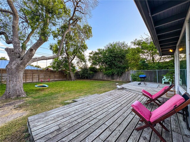 wooden deck featuring a lawn