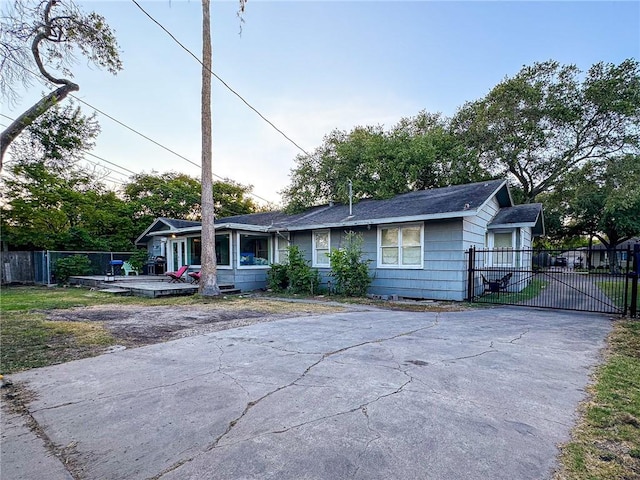 447 Santa Monica Pl, Corpus Christi, TX 78411 - view of front of house with fence, asphalt driveway, a wooden deck, a gate, and a shingled roof