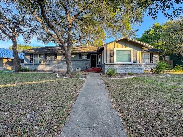 447 Santa Monica Pl, Corpus Christi, TX 78411 - single story home with board and batten siding and a front lawn