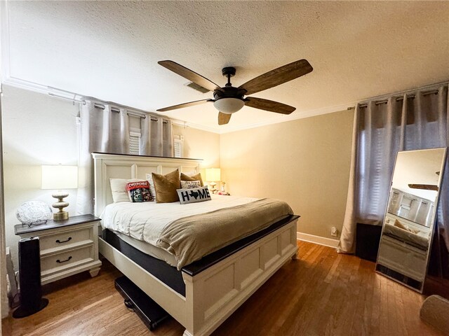 bedroom featuring a textured ceiling, crown molding, ceiling fan, and dark hardwood / wood-style floors