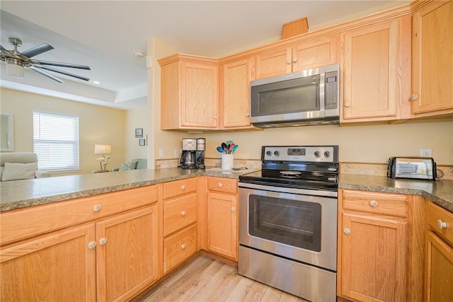 kitchen featuring kitchen peninsula, ceiling fan, light wood-type flooring, and appliances with stainless steel finishes