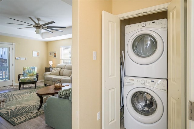 laundry area featuring hardwood / wood-style flooring, stacked washer / dryer, and ceiling fan