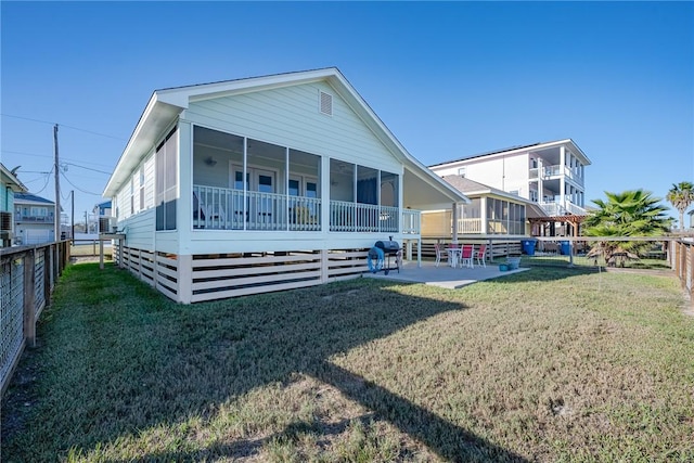 back of property featuring a yard, a patio area, and a sunroom