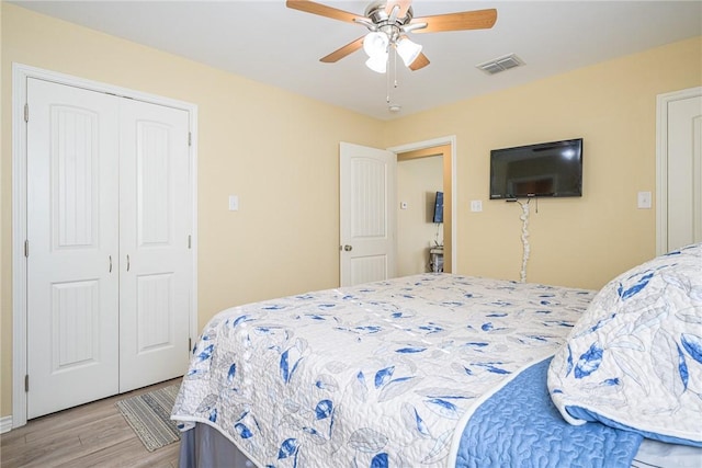 bedroom with ceiling fan, light hardwood / wood-style floors, and a closet