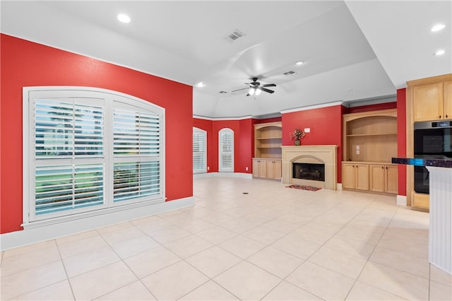 unfurnished living room featuring ceiling fan, light tile patterned floors, and a healthy amount of sunlight