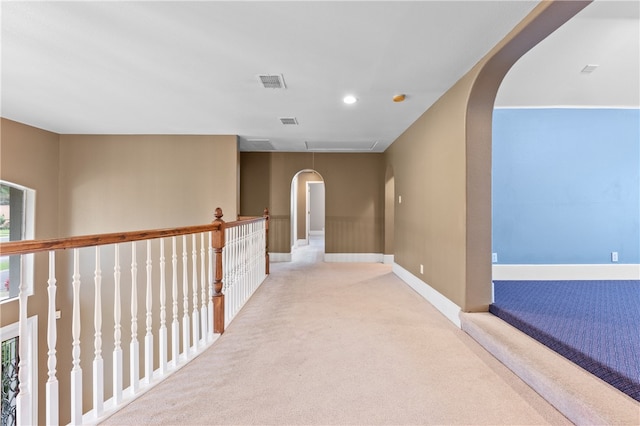 hallway featuring light colored carpet