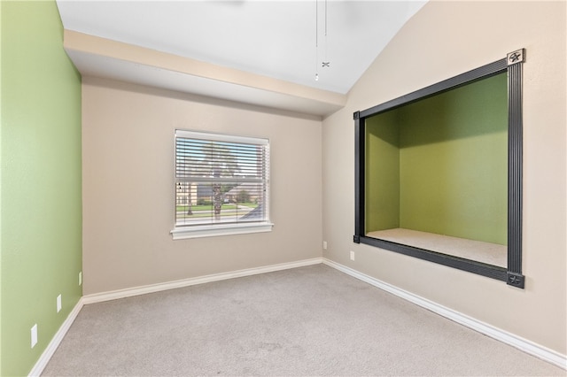 carpeted spare room featuring vaulted ceiling