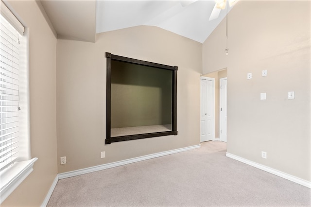 carpeted empty room featuring ceiling fan and lofted ceiling