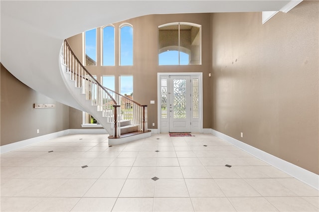 tiled entryway with a towering ceiling