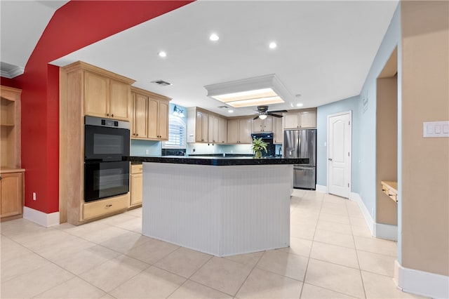 kitchen with light tile patterned floors, a kitchen island, double oven, light brown cabinets, and stainless steel fridge