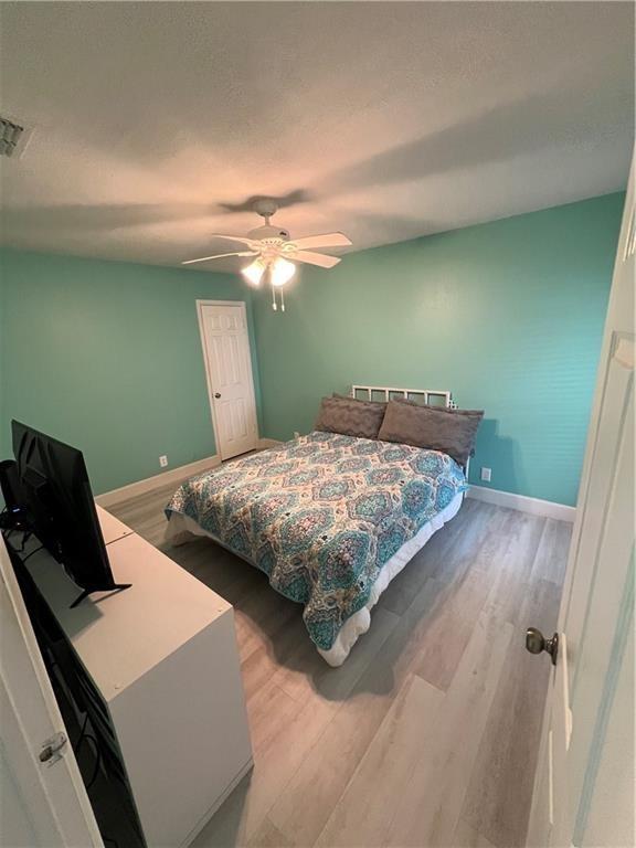 bedroom with ceiling fan and light wood-type flooring