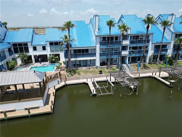 view of dock with a water view and a community pool