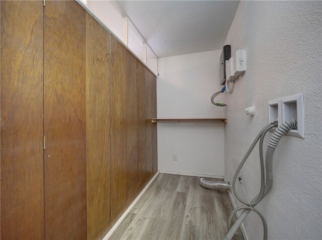 interior space with gas dryer hookup, hookup for a washing machine, and light hardwood / wood-style flooring