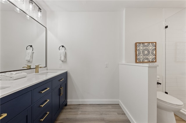 bathroom with toilet, vanity, and hardwood / wood-style flooring