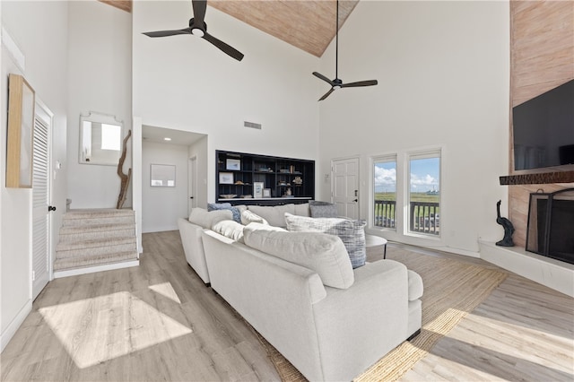 living room with high vaulted ceiling, ceiling fan, and light hardwood / wood-style flooring