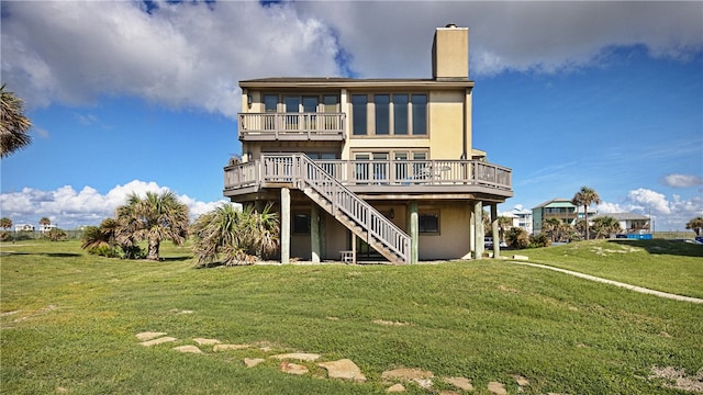 back of property with a yard and a wooden deck