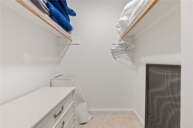 walk in closet featuring light carpet