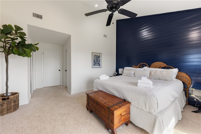 carpeted bedroom with a high ceiling and ceiling fan