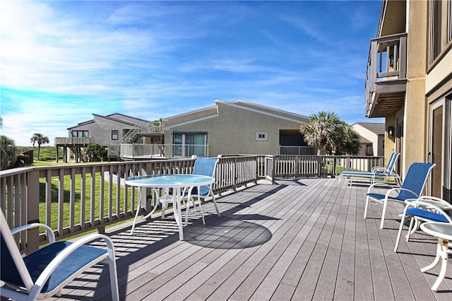 wooden deck featuring a lawn