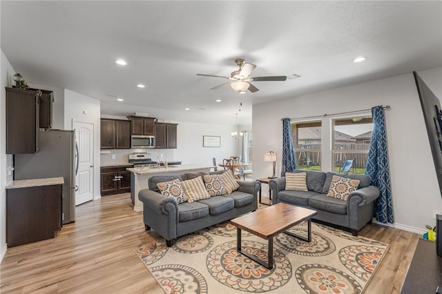 living area with light wood-type flooring, visible vents, a ceiling fan, recessed lighting, and baseboards