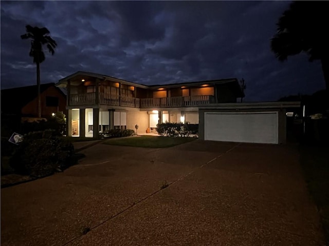 5445 Ocean Dr, Corpus Christi, TX 78412 - view of front of house with a balcony, concrete driveway, an attached garage, and stucco siding