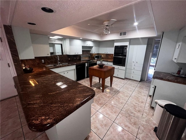 5445 Ocean Dr, Corpus Christi, TX 78412 - kitchen with black appliances, a raised ceiling, backsplash, ceiling fan, and a textured ceiling