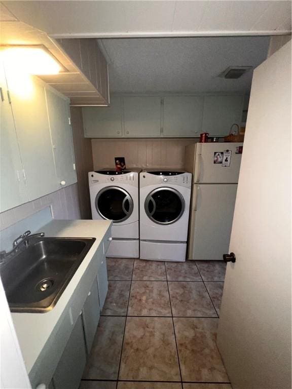 5445 Ocean Dr, Corpus Christi, TX 78412 - laundry room featuring washing machine and dryer, light tile patterned floors, and cabinet space