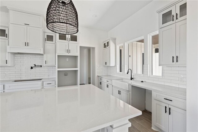 kitchen featuring a large island, dark countertops, backsplash, and white cabinetry