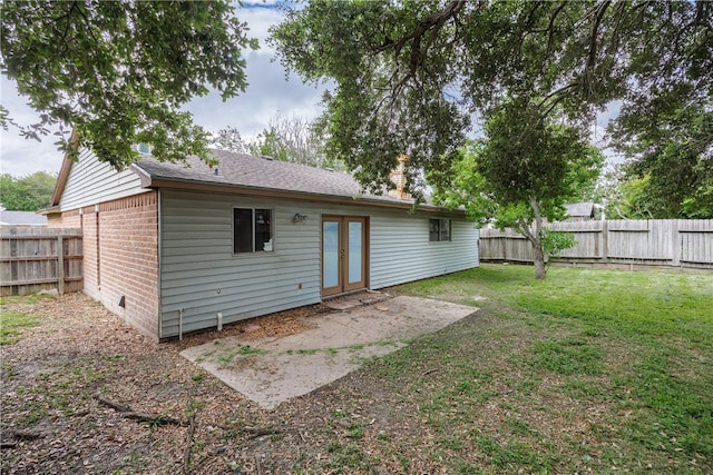 rear view of property with a yard and a patio area