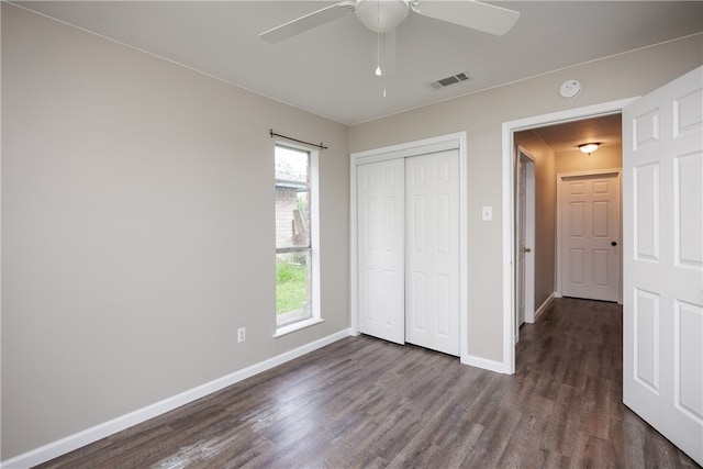 unfurnished bedroom with ceiling fan, dark hardwood / wood-style floors, and a closet