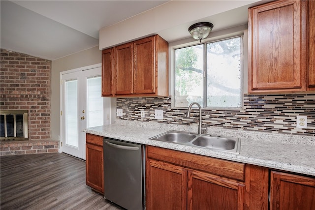 kitchen featuring a fireplace, decorative backsplash, sink, hardwood / wood-style flooring, and dishwasher