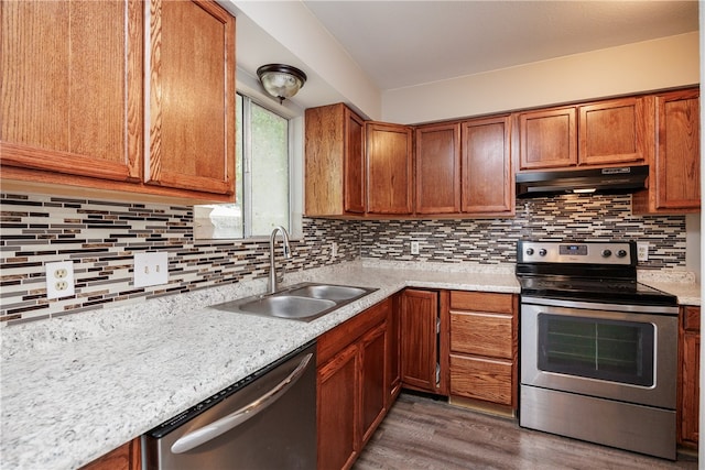 kitchen with dark wood-type flooring, backsplash, appliances with stainless steel finishes, and sink