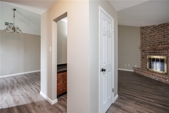 hall with a notable chandelier and dark hardwood / wood-style floors