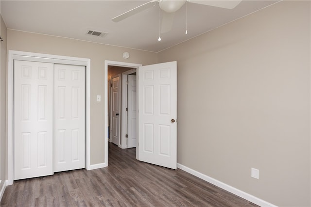 unfurnished bedroom with dark hardwood / wood-style flooring, ceiling fan, and a closet