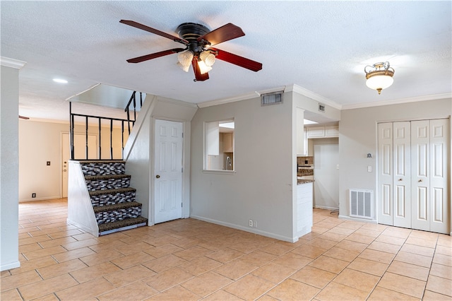 empty room with a textured ceiling, ceiling fan, and crown molding