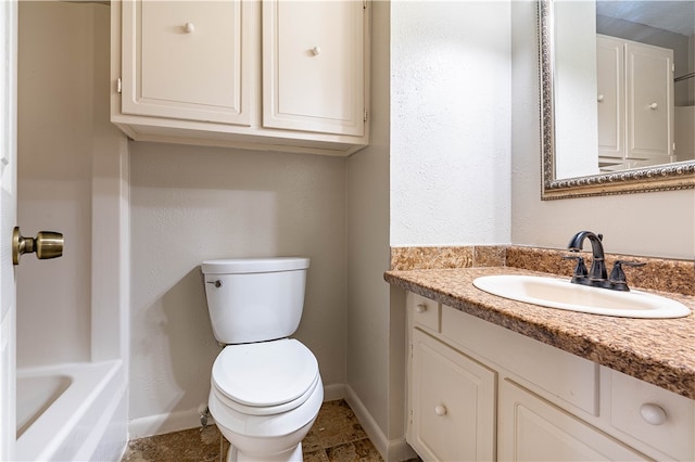 bathroom with a tub, vanity, and toilet