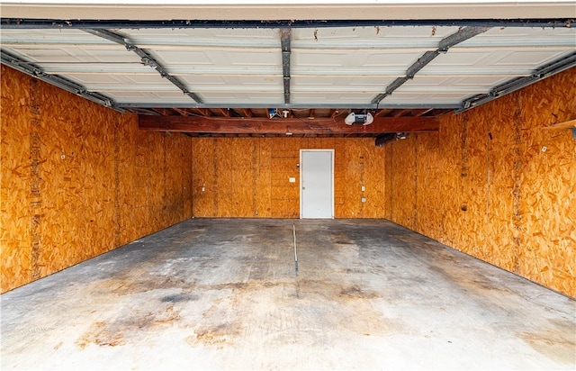 garage with a garage door opener and wooden walls