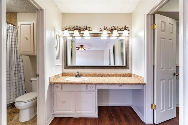 bathroom with hardwood / wood-style flooring, ceiling fan, a textured ceiling, vanity, and toilet