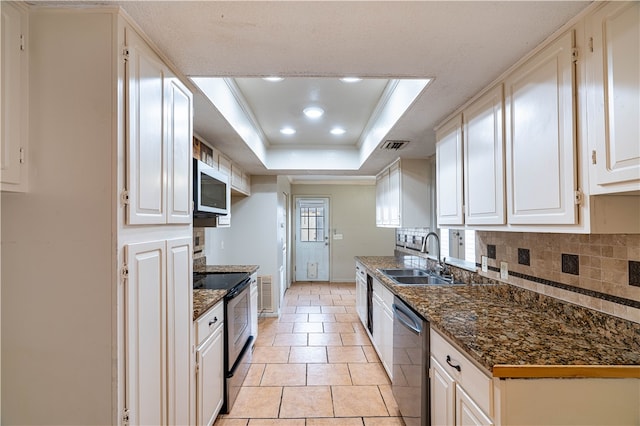 kitchen with tasteful backsplash, white cabinetry, appliances with stainless steel finishes, a raised ceiling, and sink