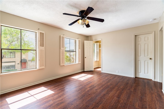 unfurnished bedroom featuring multiple windows, a textured ceiling, ceiling fan, and dark hardwood / wood-style floors