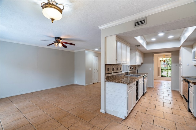 kitchen with white cabinetry, sink, tasteful backsplash, ornamental molding, and dark stone countertops