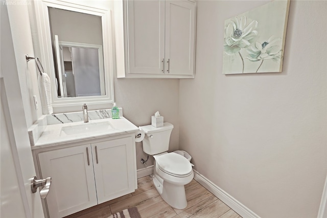 bathroom featuring toilet, vanity, and wood-type flooring