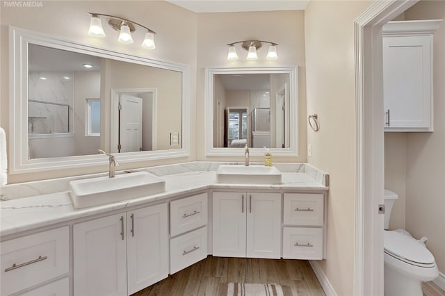 bathroom with vanity, hardwood / wood-style flooring, toilet, and a shower