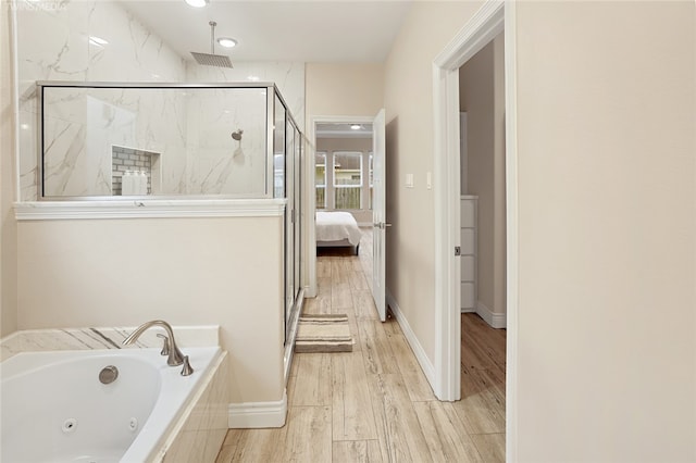 bathroom with hardwood / wood-style floors and shower with separate bathtub