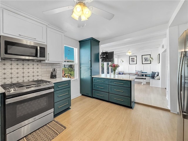 kitchen featuring light countertops, appliances with stainless steel finishes, light wood-style floors, and green cabinetry