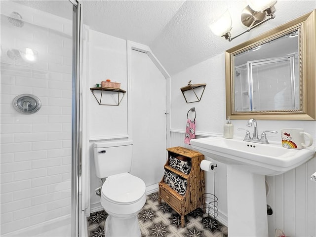 full bathroom with toilet, a shower stall, vaulted ceiling, and a textured ceiling